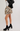 Person wearing a floral mini skirt with black platform boots on a plain background