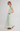 Woman wearing a light green dress with a white background