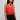 Woman wearing a coral top and black lace shorts on a plain background