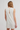 White sleeveless dress with cut-out back on a plain background
