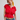 Woman wearing a red top and blue jeans against a plain background