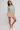 Woman wearing a light blue sweater and checkered shorts on a white background
