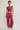 A model wearing a matching dusty rose two-piece lounge set consisting of a sleeveless crop top and wide-leg sweatpants, paired with white sneakers, against a plain light gray studio background.