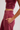 A close-up of a person wearing dusty rose pink athletic loungewear, featuring a ruched crop top and matching jogger sweatpants with side pockets.