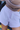 Close-up of a person wearing light lavender sweat shorts with a matching drawstring waist and a taupe sweatshirt partially visible.