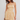 Woman wearing a yellow and white striped dress against a plain background