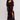 Woman wearing a black floral dress with a slit on a white background