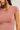 Close-up of a person wearing a pink t-shirt against a white background
