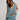 Woman wearing a floral ruffled dress against a plain background
