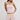 Woman wearing a pastel striped outfit on a white background
