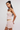 Woman wearing a pastel striped dress on a plain background