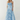 Woman wearing a blue strapless dress on a white background