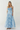 Woman wearing a blue strapless dress on a white background