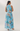 Woman wearing a blue floral dress against a white background