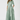 Woman wearing a light green dress with a belt on a white background