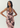 A woman modeling a sleeveless pink cowl-neck dress with a dark floral print, posed against a light gray studio background.