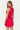 Woman wearing a red dress with floral details on a white background