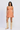 Woman wearing a patterned dress and beige cowboy boots on a white background