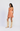 Woman wearing an orange patterned dress and beige cowboy boots on a white background