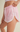 Pink shorts with white trim worn by a person on a beige background
