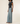 A model wearing a dark charcoal gray short-sleeve t-shirt and light-wash wide-leg denim jeans, standing against a plain off-white studio background.
