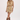 A woman modeling a sleeveless cream-colored mini dress with a vintage floral pattern, styled with a straw cowboy hat and brown leather cowboy boots against a plain white studio background.