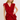 Woman wearing a red ruffled dress on a plain background