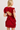 Red ruffled dress with open back worn by a model on a white background