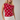 Woman wearing a red polka dot top and white shorts against a plain background