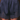A close-up of a person wearing navy blue satin shorts with a gathered elastic waistband and dark lace trim at the hem, shown against a dark brown background.