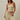 Woman wearing a yellow and white striped strapless top and pants against a beige background