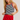 Woman wearing a black and white striped tank top with red trim and a red skirt.