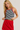 Woman wearing a black and white striped tank top with red trim and a red skirt.