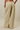 Wide-leg pants with horizontal yellow and gray stripes, shown on a model from the back against a solid beige studio background.