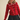 Woman wearing a red sweater with heart patterns and a black skirt on a beige background