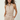 Woman wearing a beige romper with a belt on a white background
