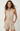 Woman wearing a beige romper with a belt on a white background