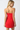 Woman wearing a red strapless dress on a white background