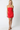 Woman wearing a strapless red dress on a white background