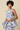 Woman wearing a floral dress with a beige background