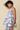 Young girl wearing a floral dress against a beige background