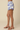 Floral shorts worn by a person on a beige background