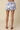 Floral shorts worn by a person on a beige background