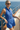 Woman in a blue romper on a yacht with ocean in the background