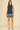 Navy sleeveless dress with white floral embroidery on a beige background