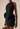 Black dress with a large floral detail on a beige background