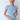 Woman wearing a blue and white checkered shirt and light blue jeans against a white background