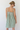 Woman wearing a green and white striped dress against a white background