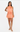 Woman wearing a peach-colored dress on a white background
