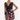 A woman modeling a sleeveless black wrap mini dress with a cowl neckline, tie waist, and a colorful floral print, set against a plain white studio background.